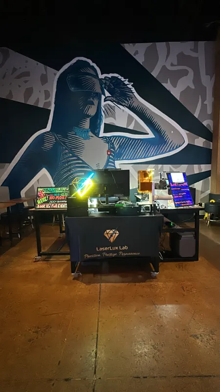 LaserLux Lab booth set up under a wall mural at an event